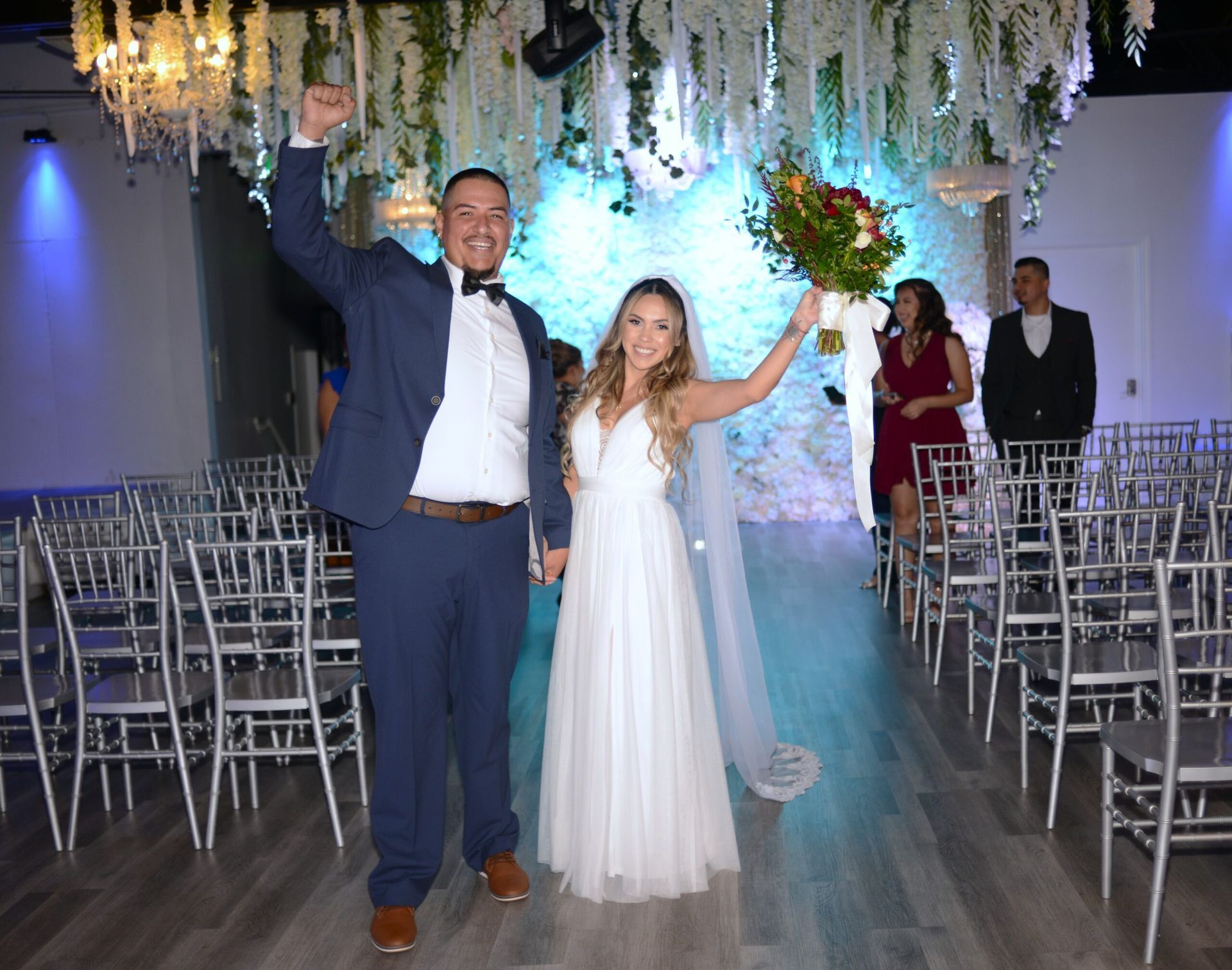 A bride and groom are walking down the aisle at their wedding holding hands.