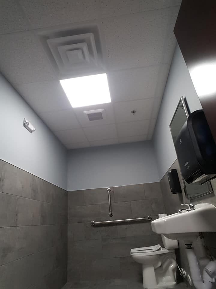 acoustic ceiling and grid installed in a commercial bathroom