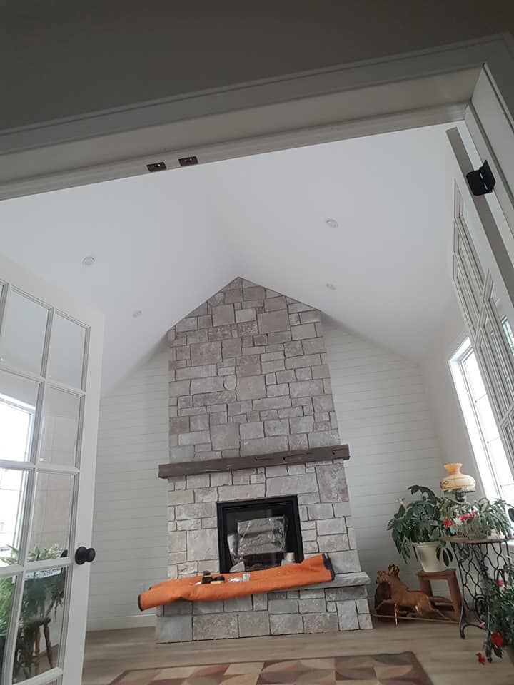 vaulted ceiling around a stone fireplace and mantle