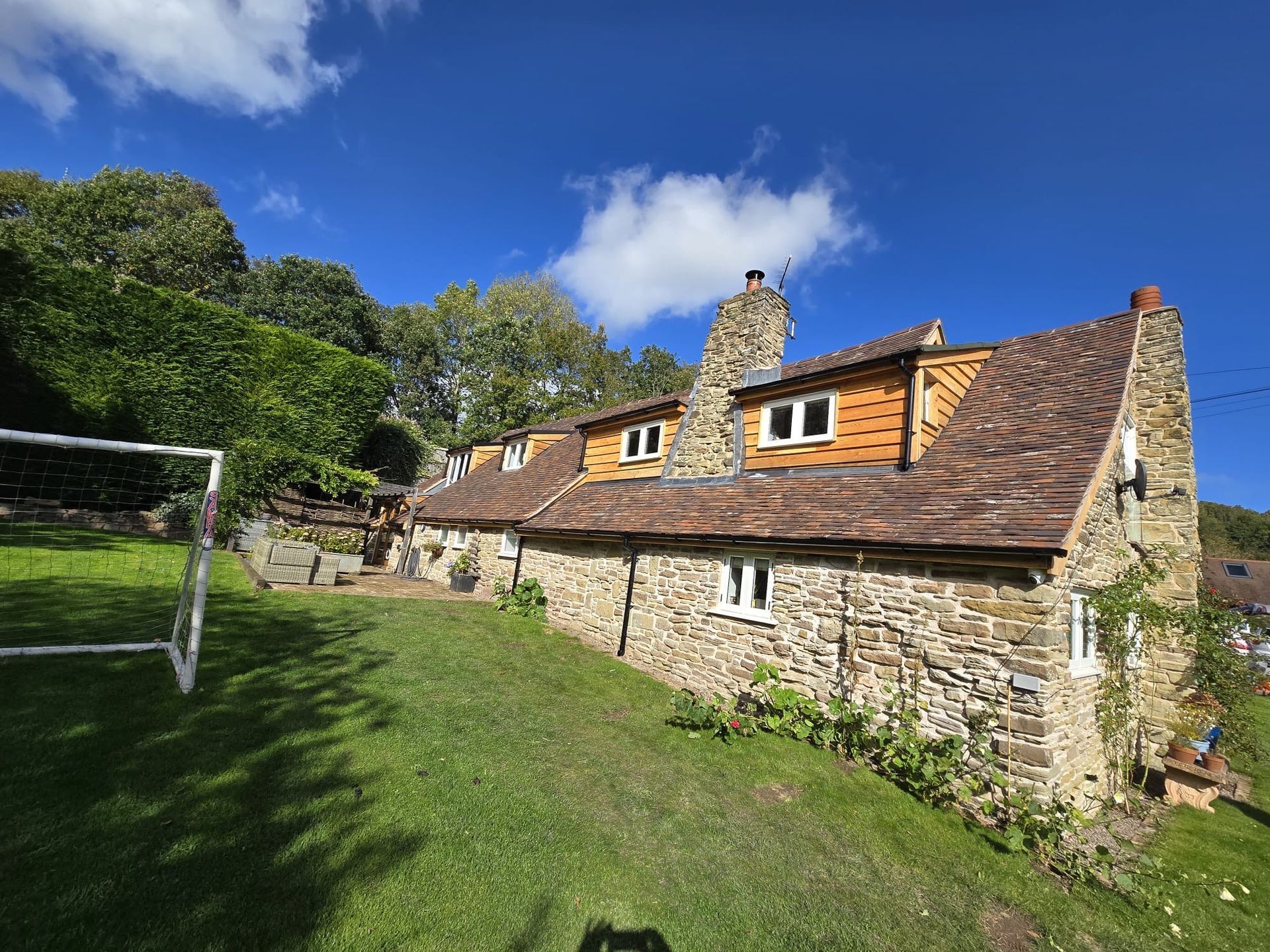A large stone house with a soccer goal in front of it.