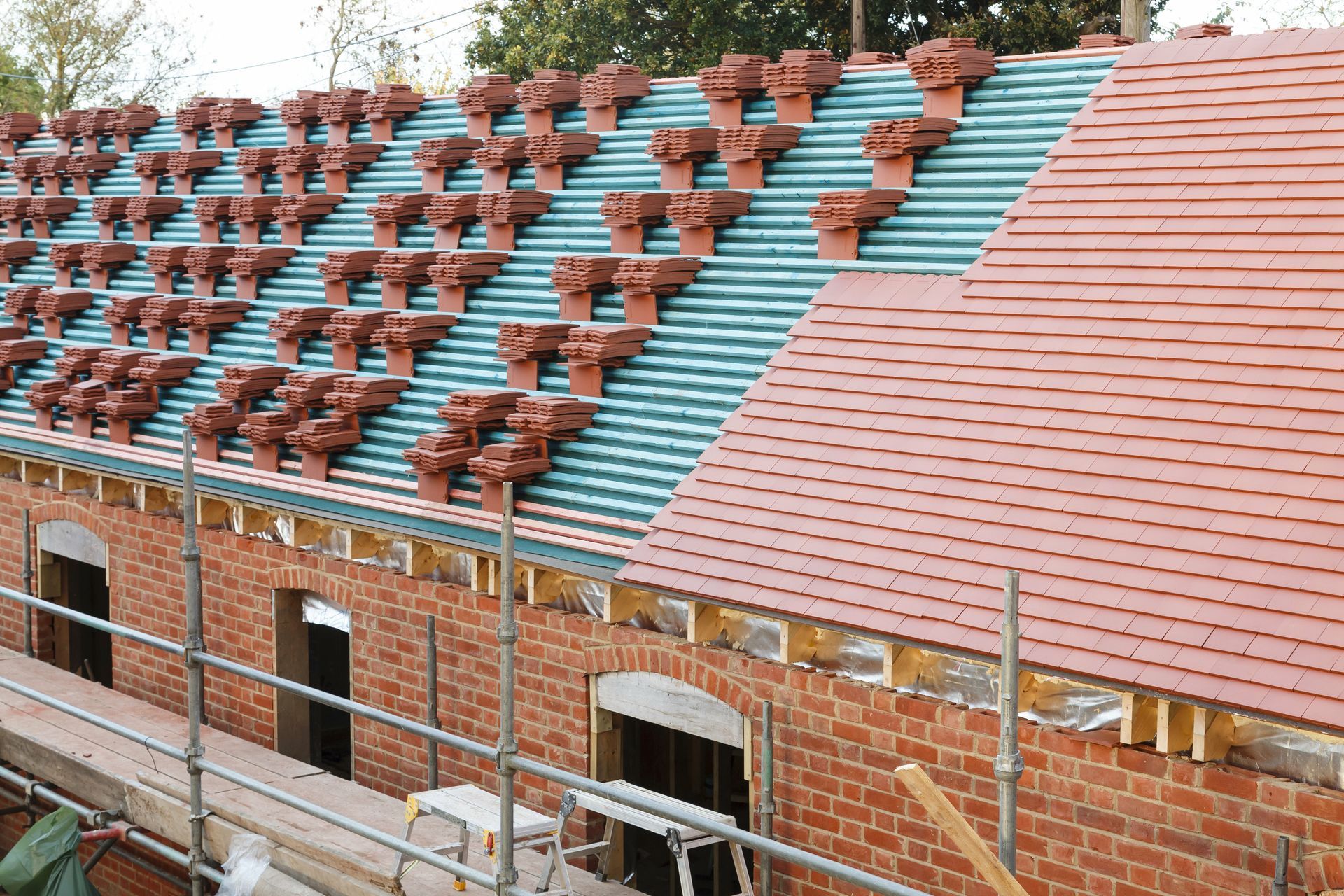 A brick building with a tiled roof is being built.