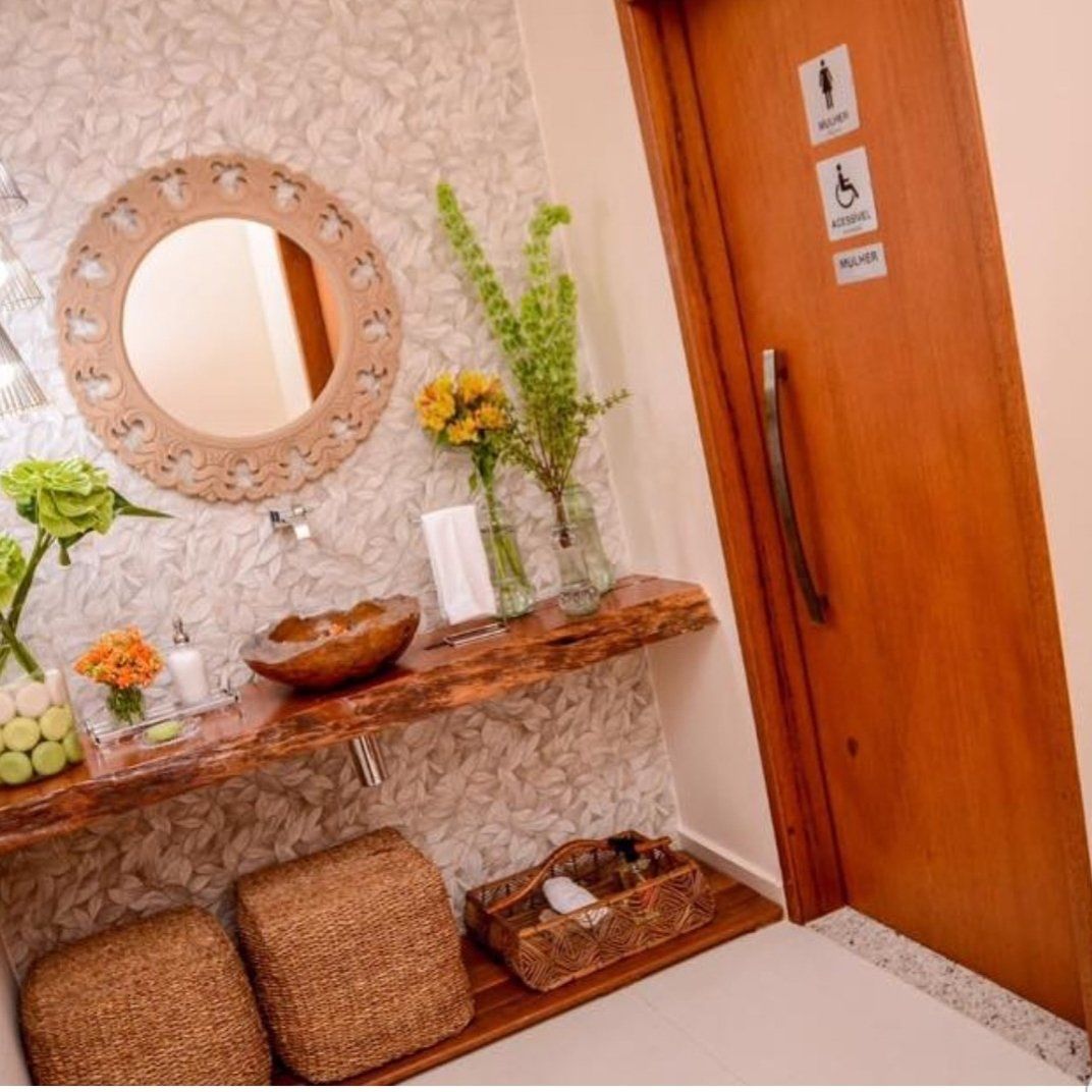 Um banheiro com uma porta de madeira, uma pia e um espelho