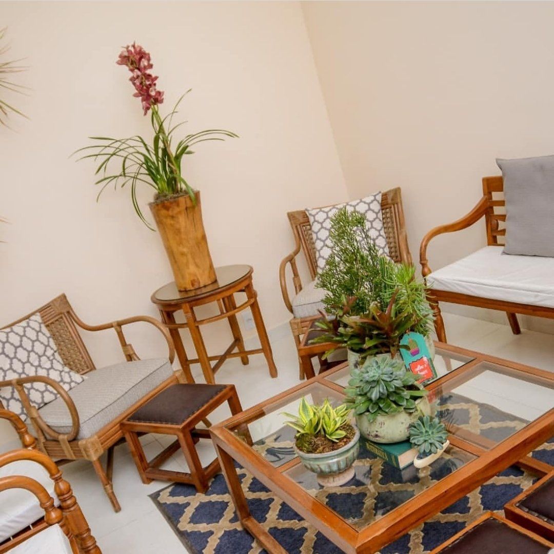 Uma sala de estar com cadeiras e uma mesa com plantas