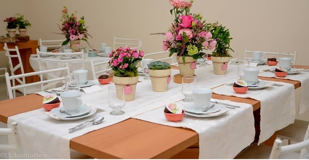 Uma longa mesa com flores em vasos sobre ela