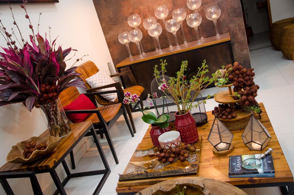 Uma sala de estar com uma mesa de madeira, cadeiras e flores.