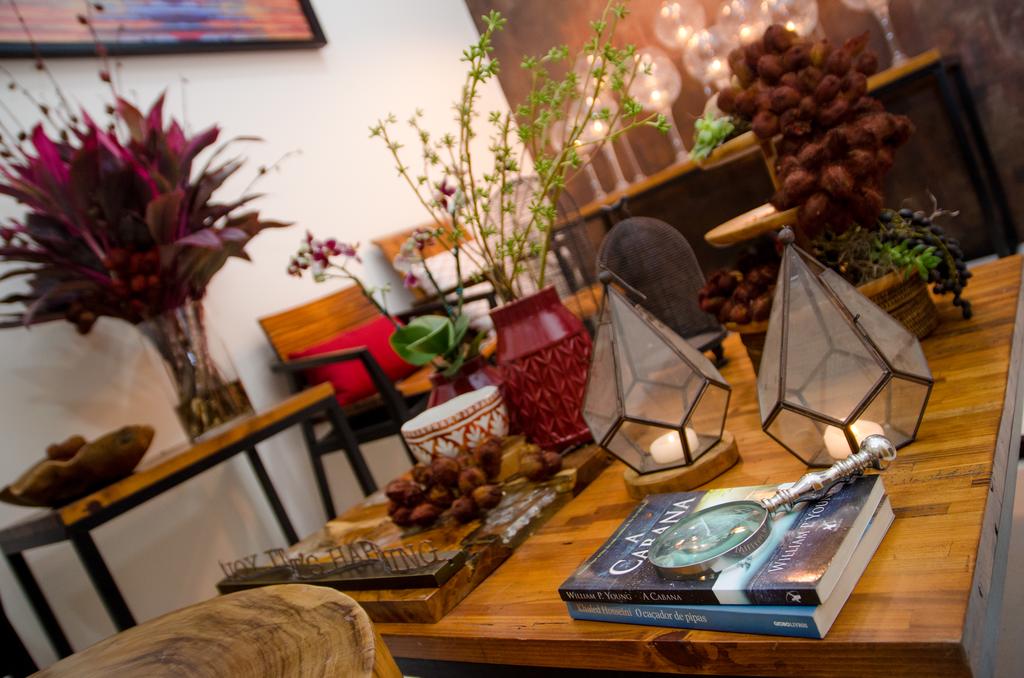 Uma mesa de madeira com um livro e velas em cima dela em uma sala de estar.