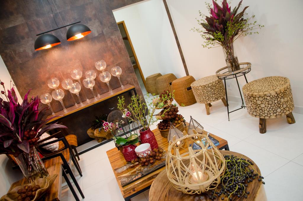 Uma sala de estar cheia de móveis e flores e uma mesa com taças de vinho.