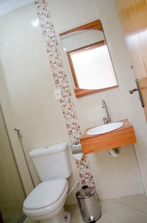 Um banheiro com um vaso sanitário, uma pia e um espelho