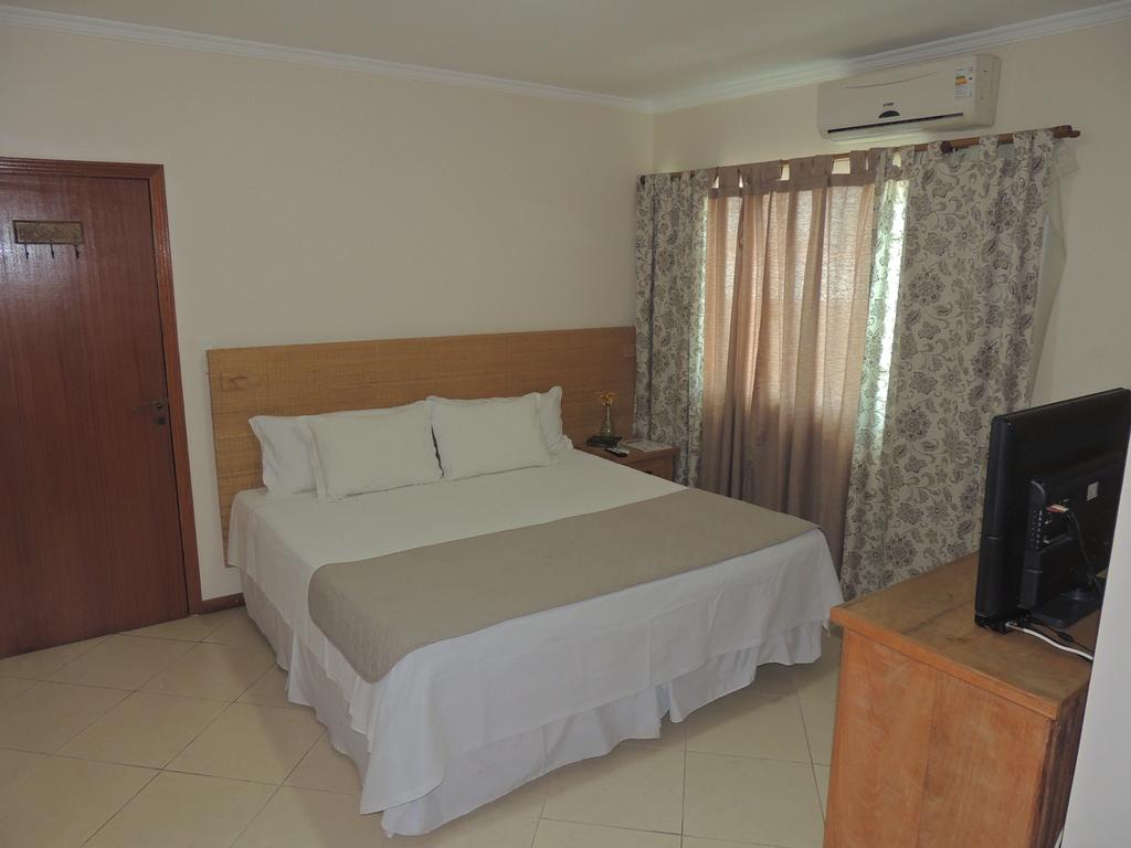 Um quarto de hotel com uma cama grande e uma televisão