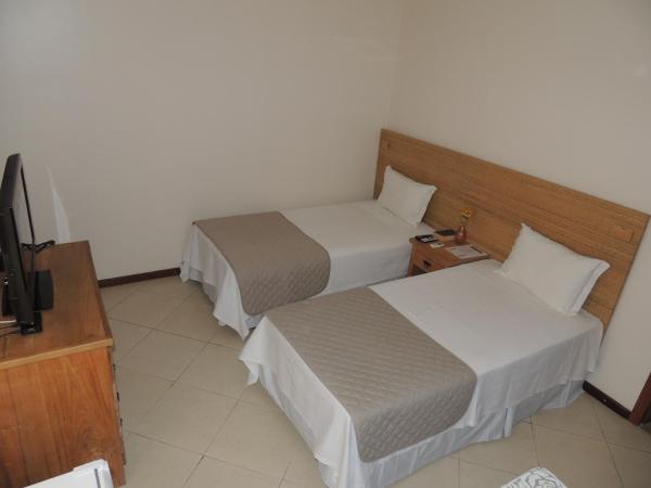 Um quarto de hotel com duas camas e uma TV de tela plana
