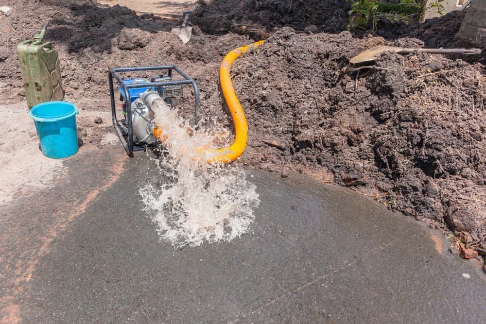 A Water Pump Spewing Water Onto Pavement — Far Northern Concrete Pumping in Croydon, QLD