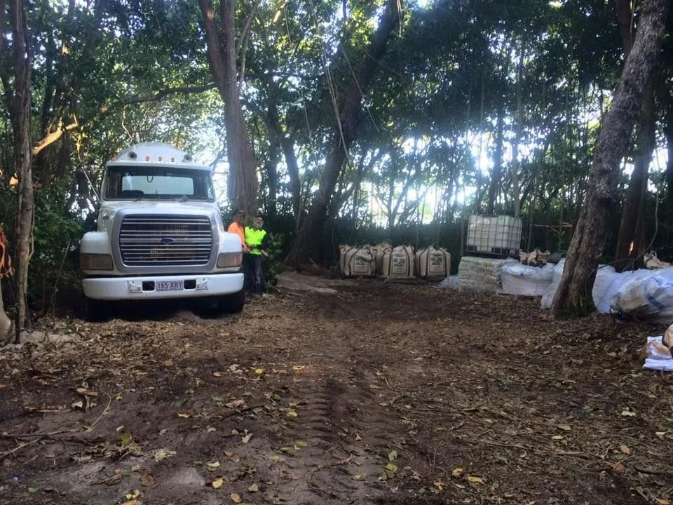 White Truck Parked in Wooded Area With Worker, Bags, and Pallets — Far Northern Concrete Pumping in Croydon, QLD
