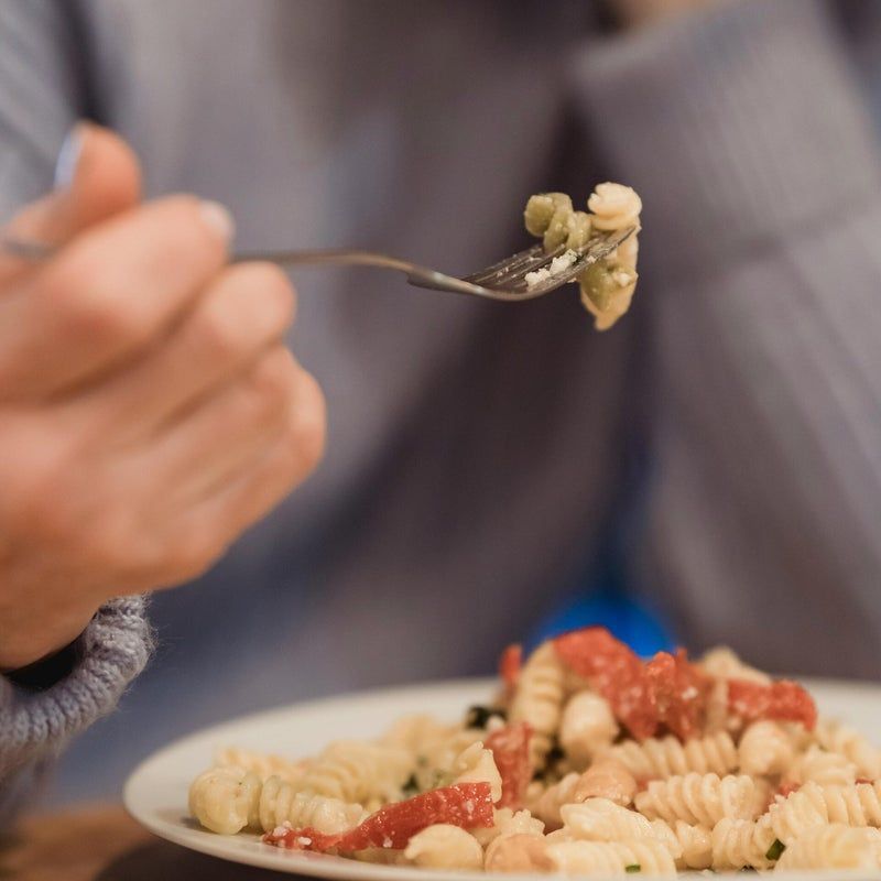 Persona che mangia un piatto di pasta