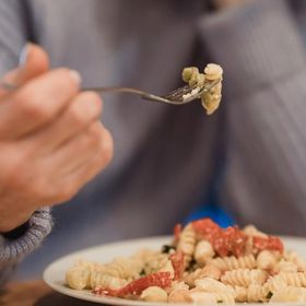 Persona che mangia un piatto di pasta