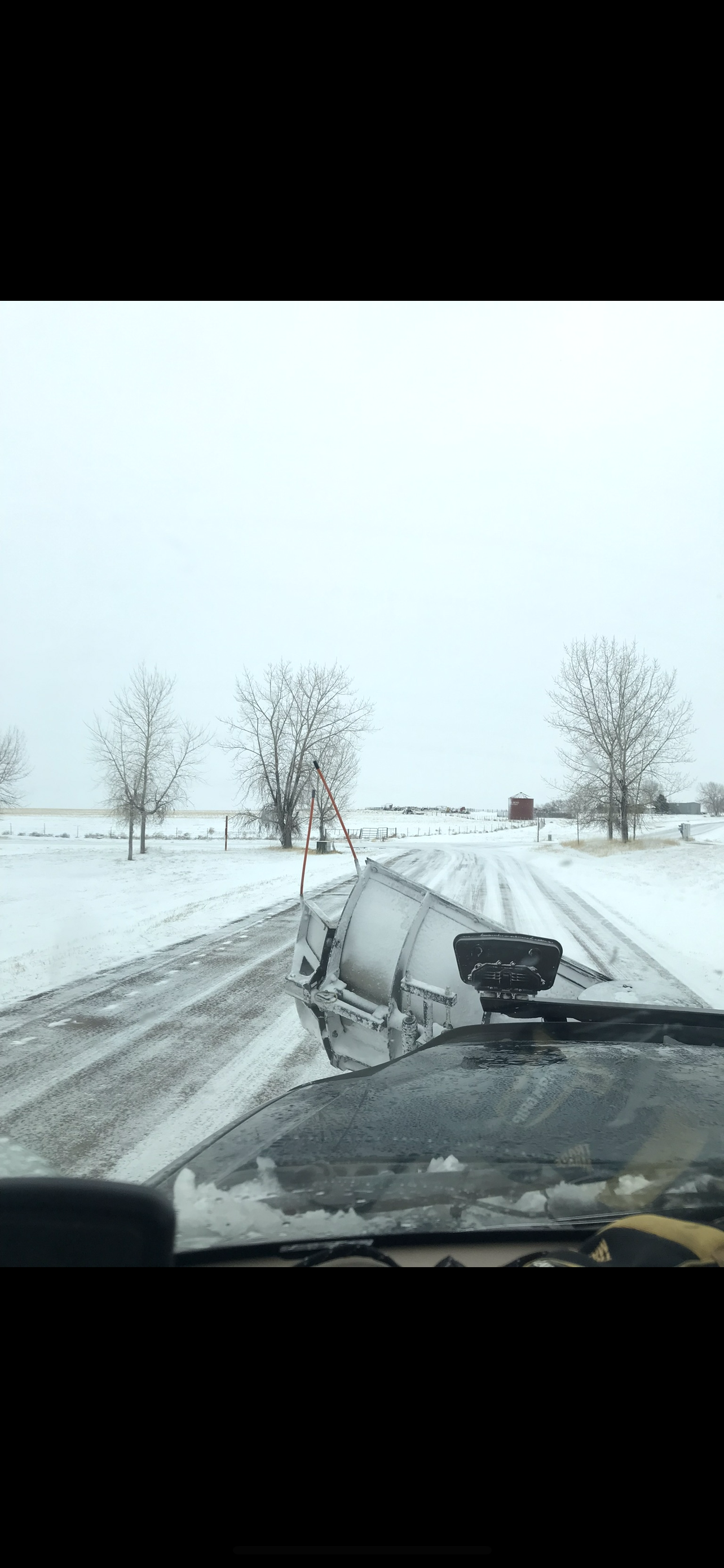 A car is driving down a snowy road.