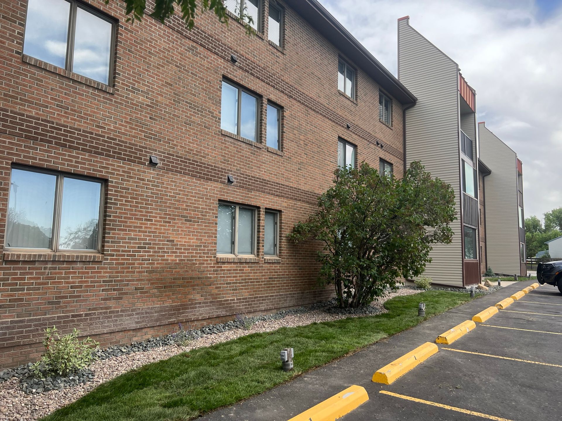 A large brick building with a parking lot in front of it.