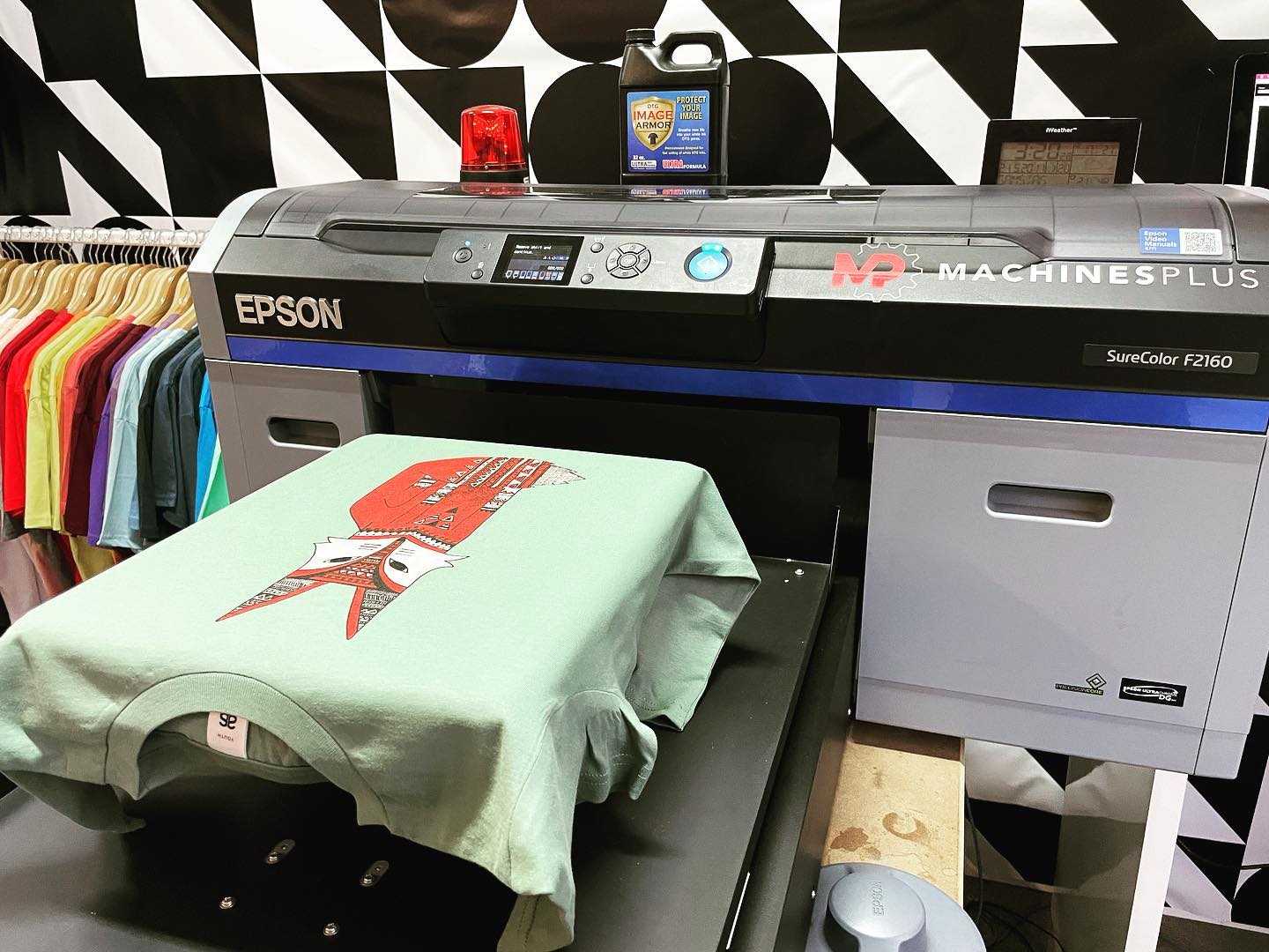 Epson SC-F2160 DTG printer with a print example on a green t-shirt.