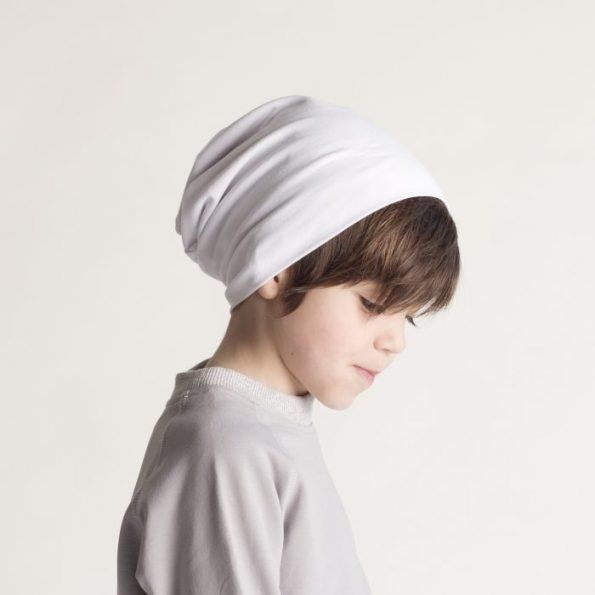 Child wearing a white beanie and light grey top