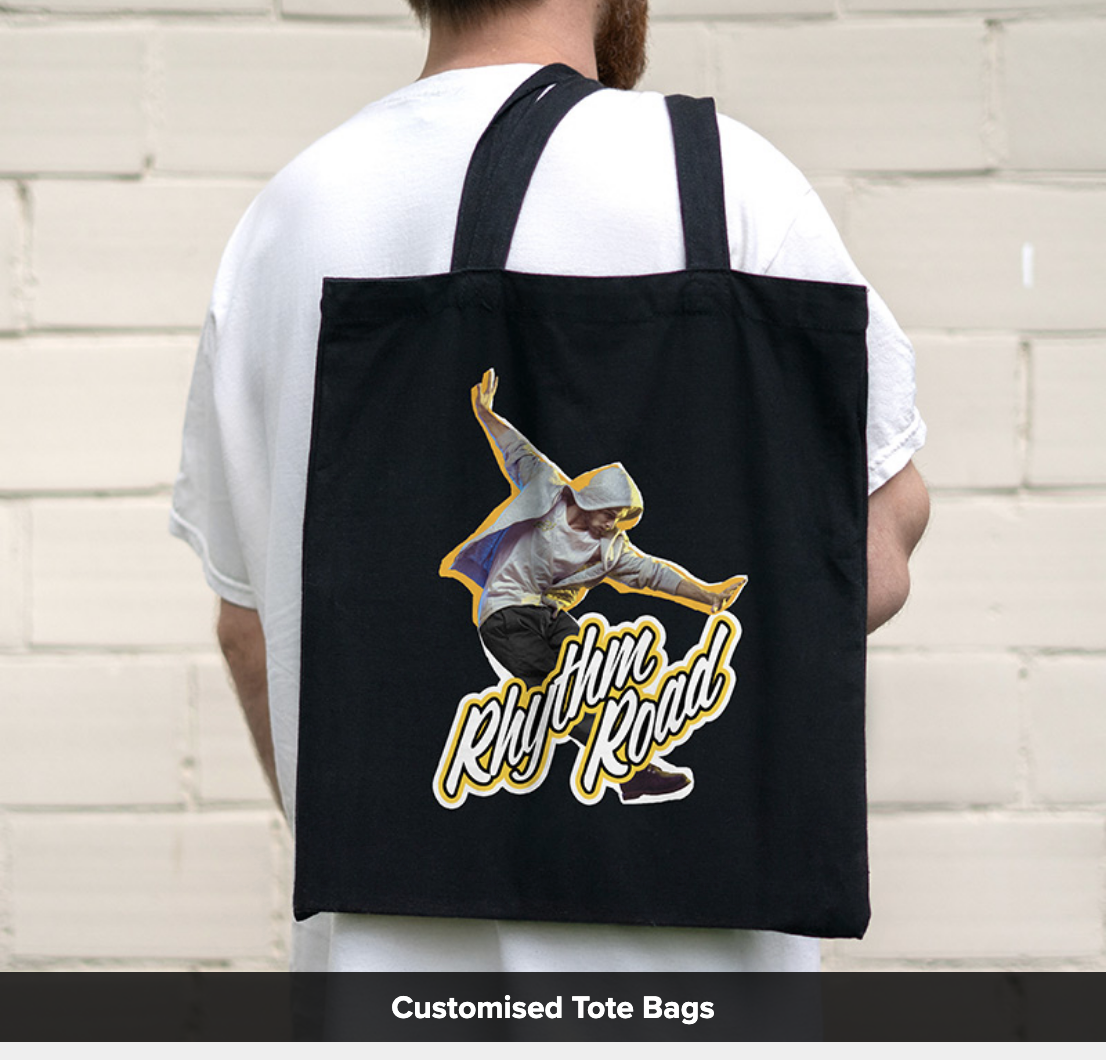 Man holding a black tote bag over his shoulder with a print example from the Roland DG BN2-20 printer.