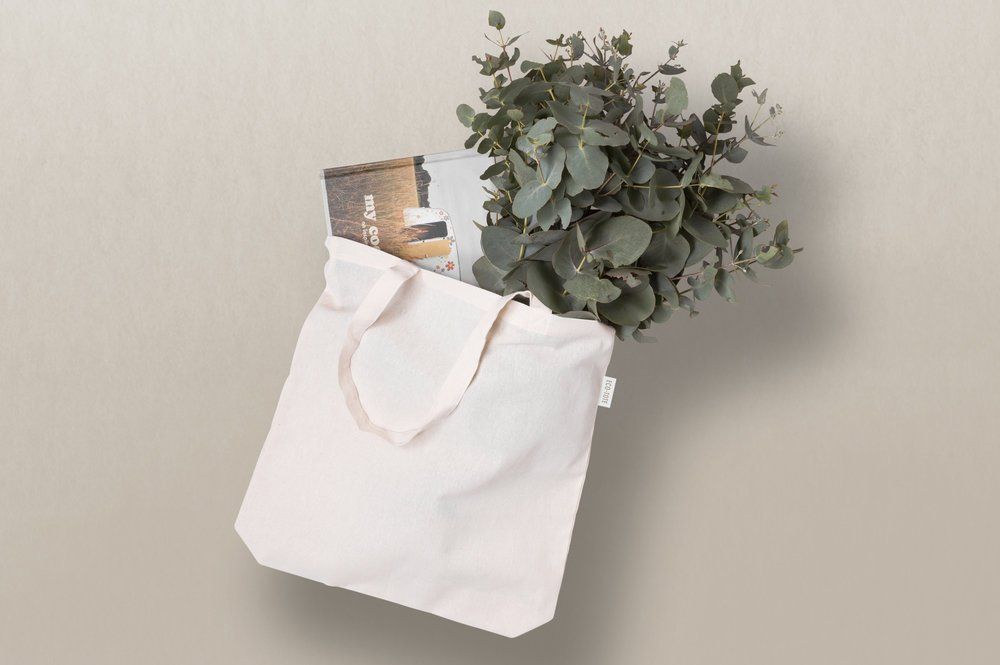 white tote bag with leaves and a book
