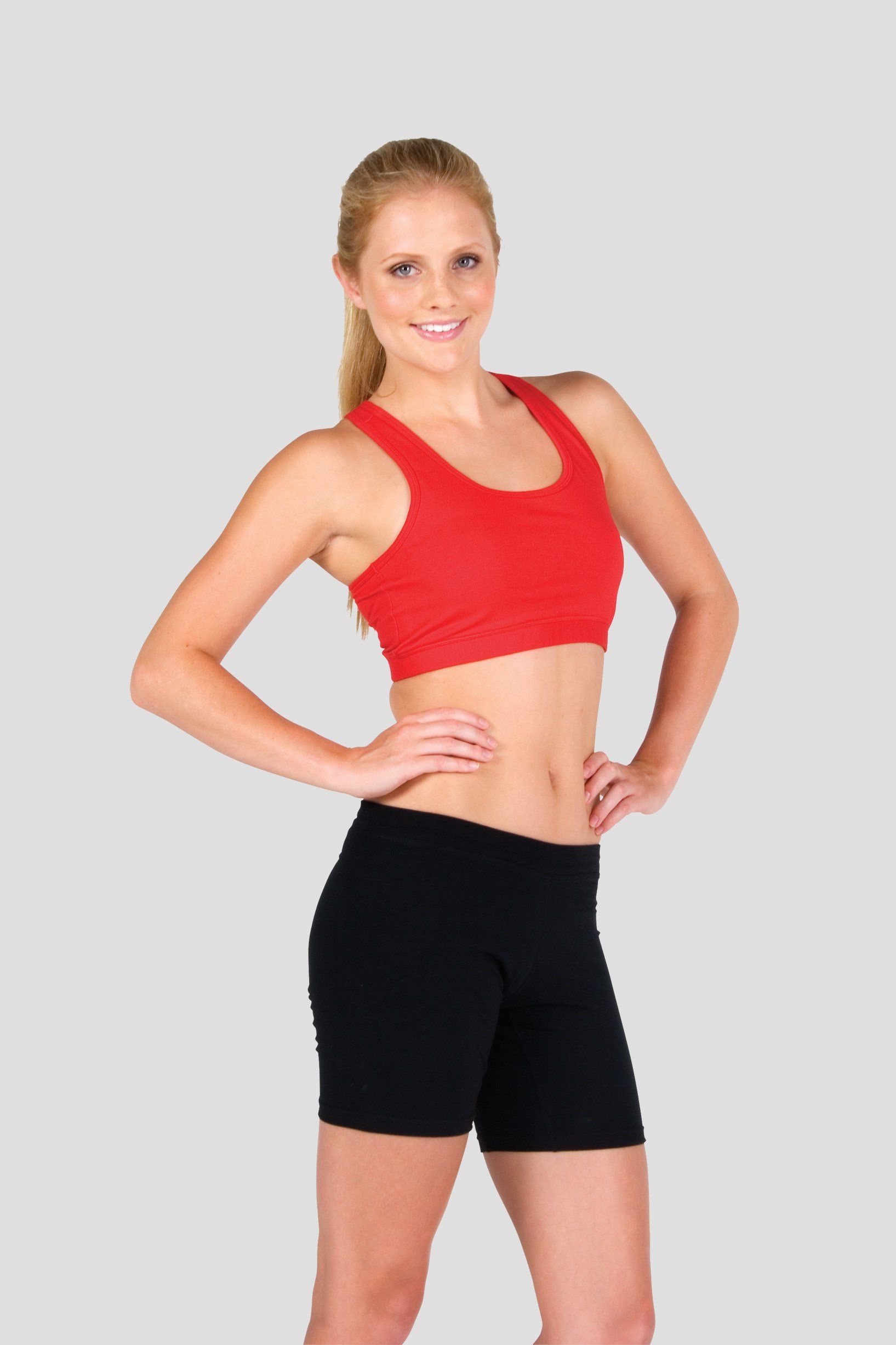 young woman wearing a red sports bra and lycra leggings