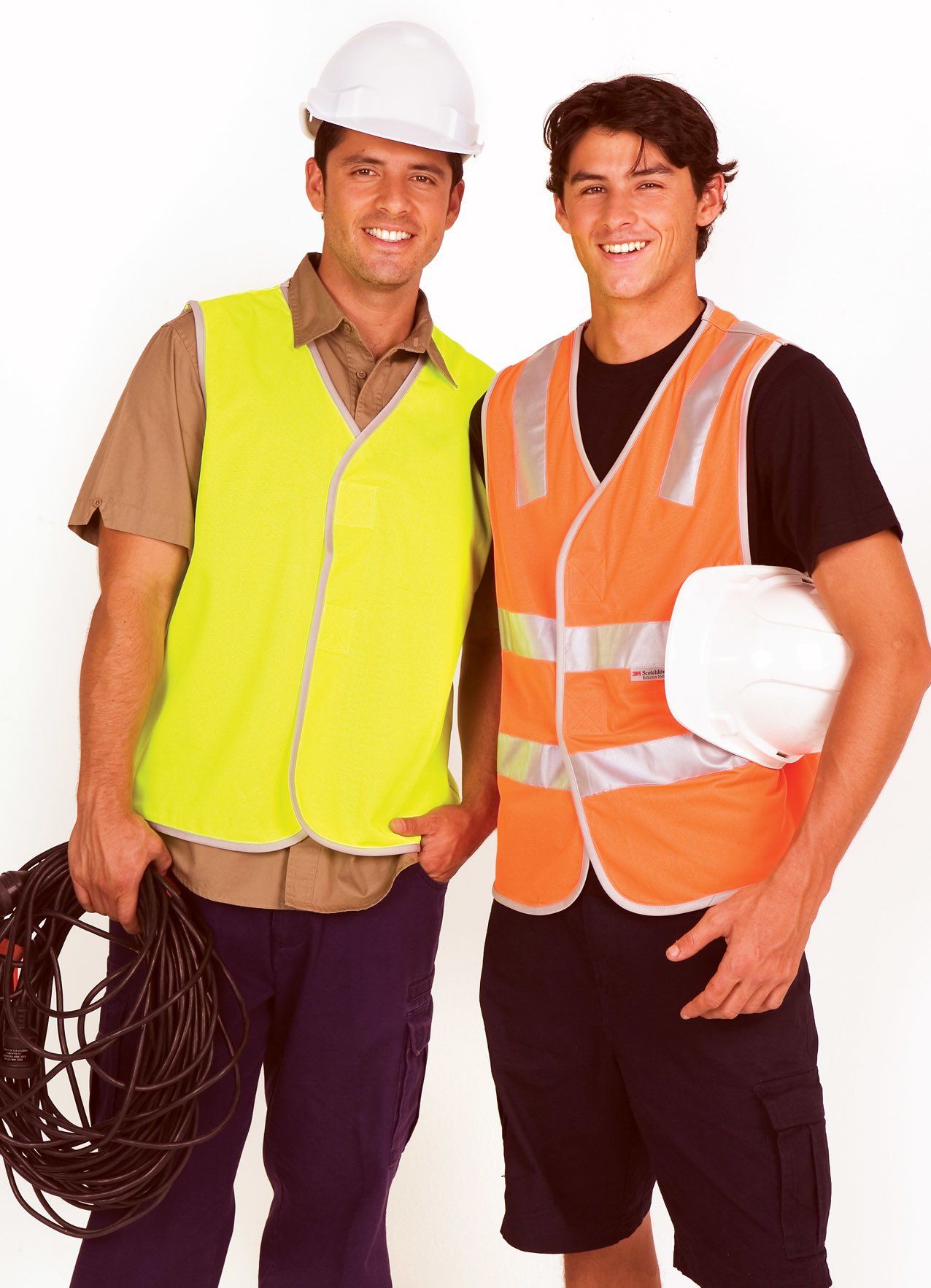 two men wearing high vis vests holding hard hat and power cords