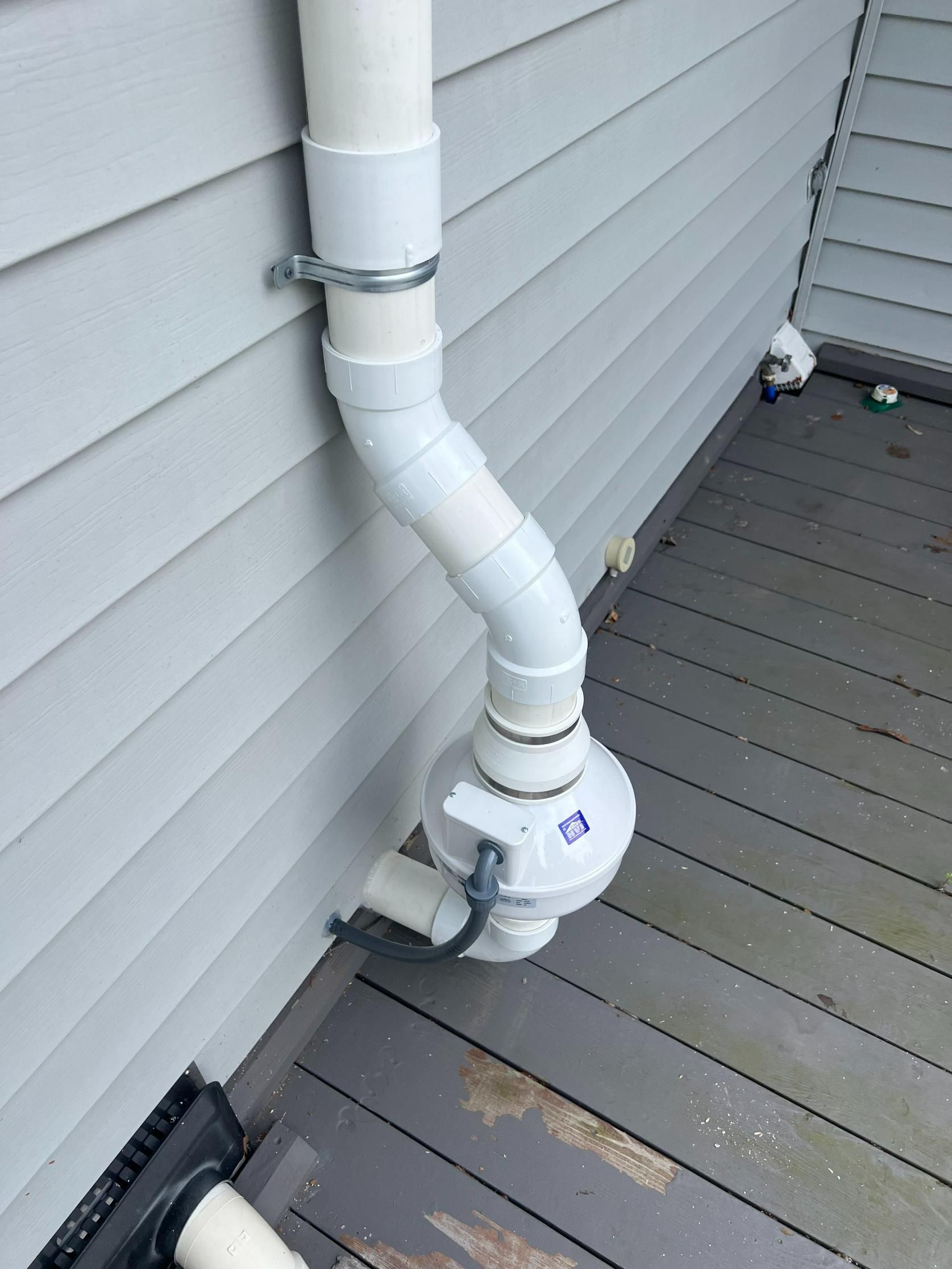 White plumbing vent pipe attached to a house exterior.
