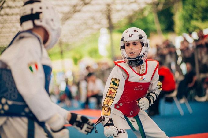 Due atleti di taekwondo si allenano su un tatami blu, uno con l'equipaggiamento protettivo rosso e l'altro con quello blu.