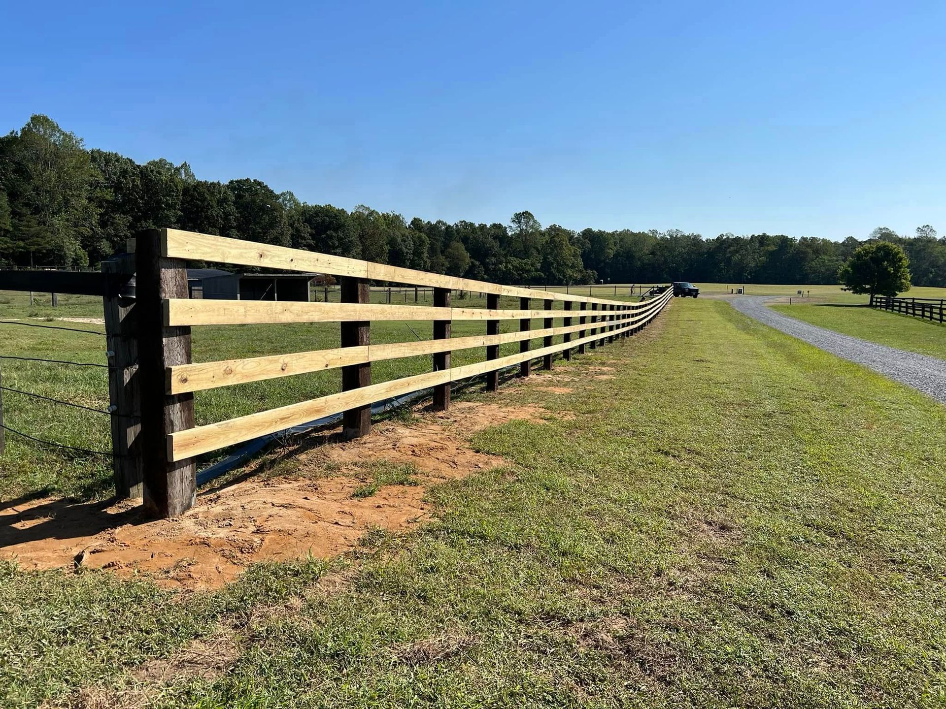 A wooden fence is sitting in the middle of a grassy field.