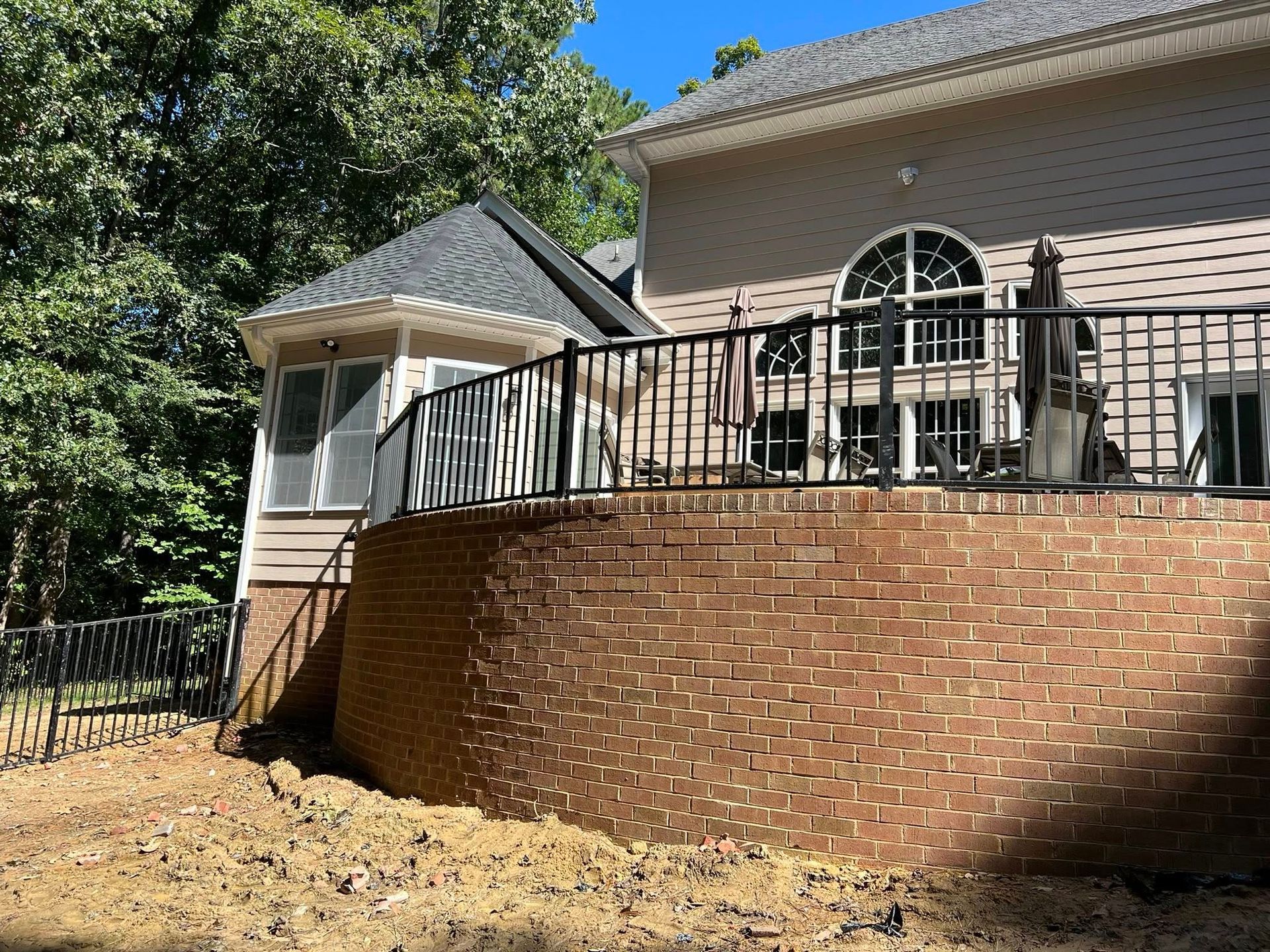 A large house with a brick wall and a balcony.