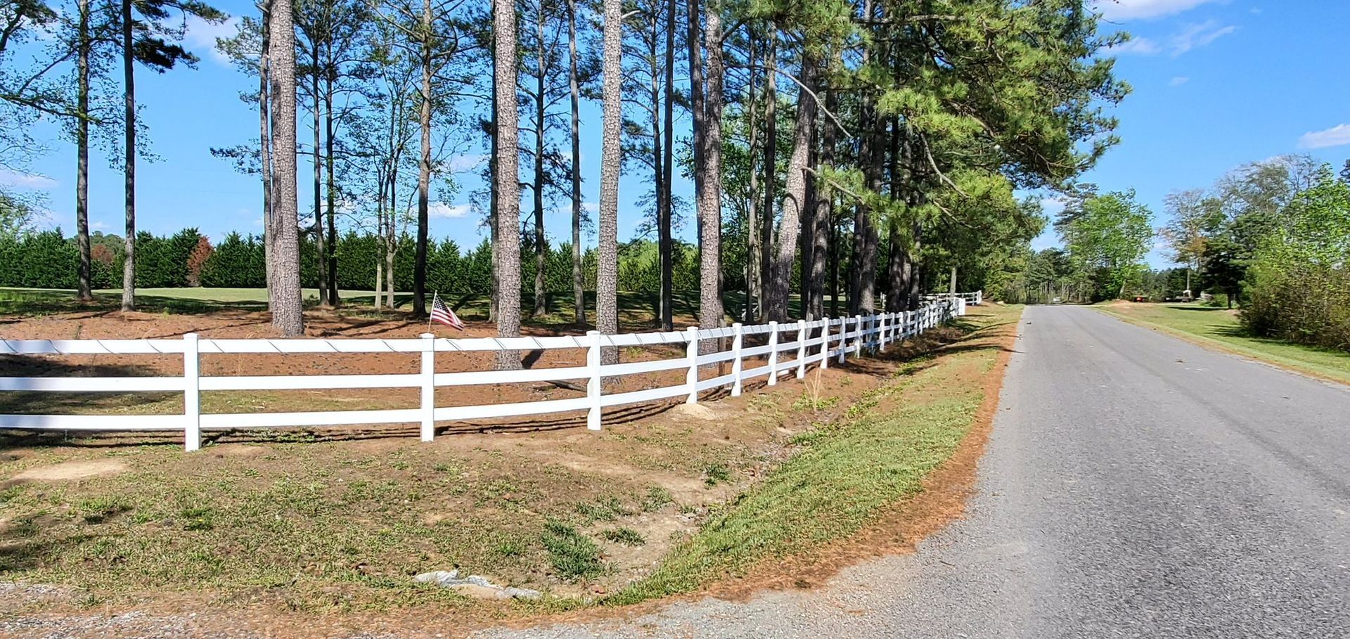 A white fence along the side of a road