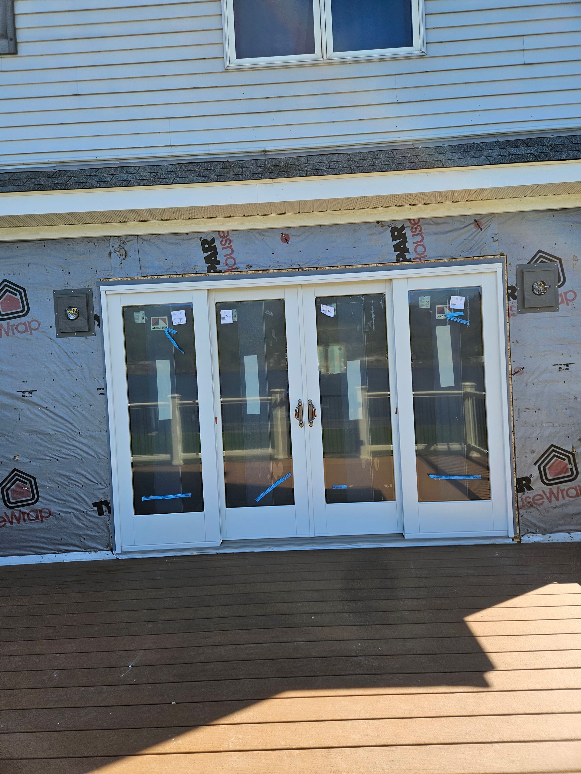 White storefront with glass double doors and windows under a striped awning on a brick walkway
