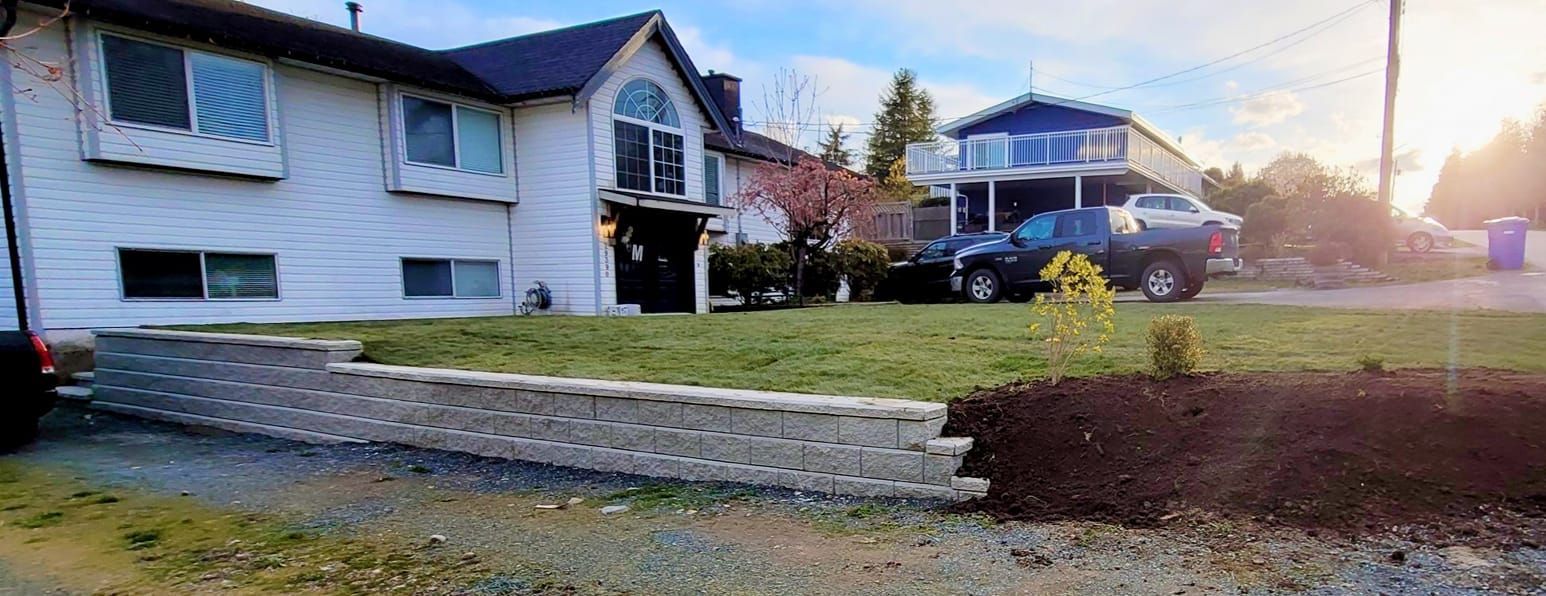 A two-story white house with a car parked on the lawn. A blue house is in the background.