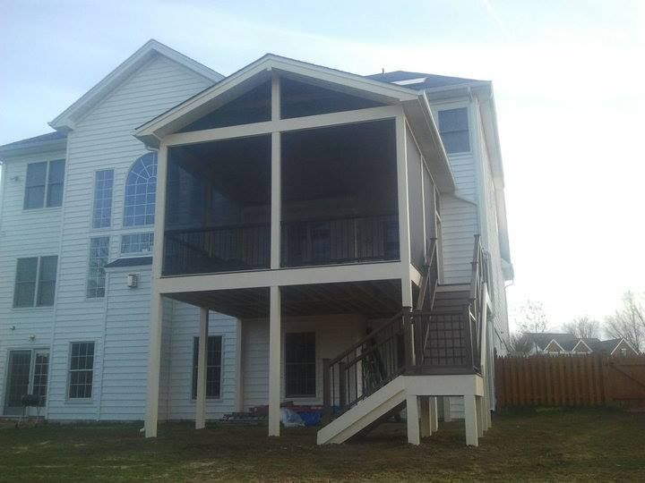 Two-story white house with a screened-in porch and exterior stairs.