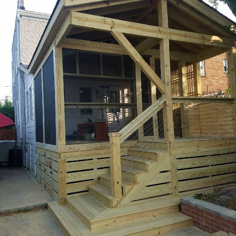 A wooden porch with stairs and a screened-in area, attached to a house.