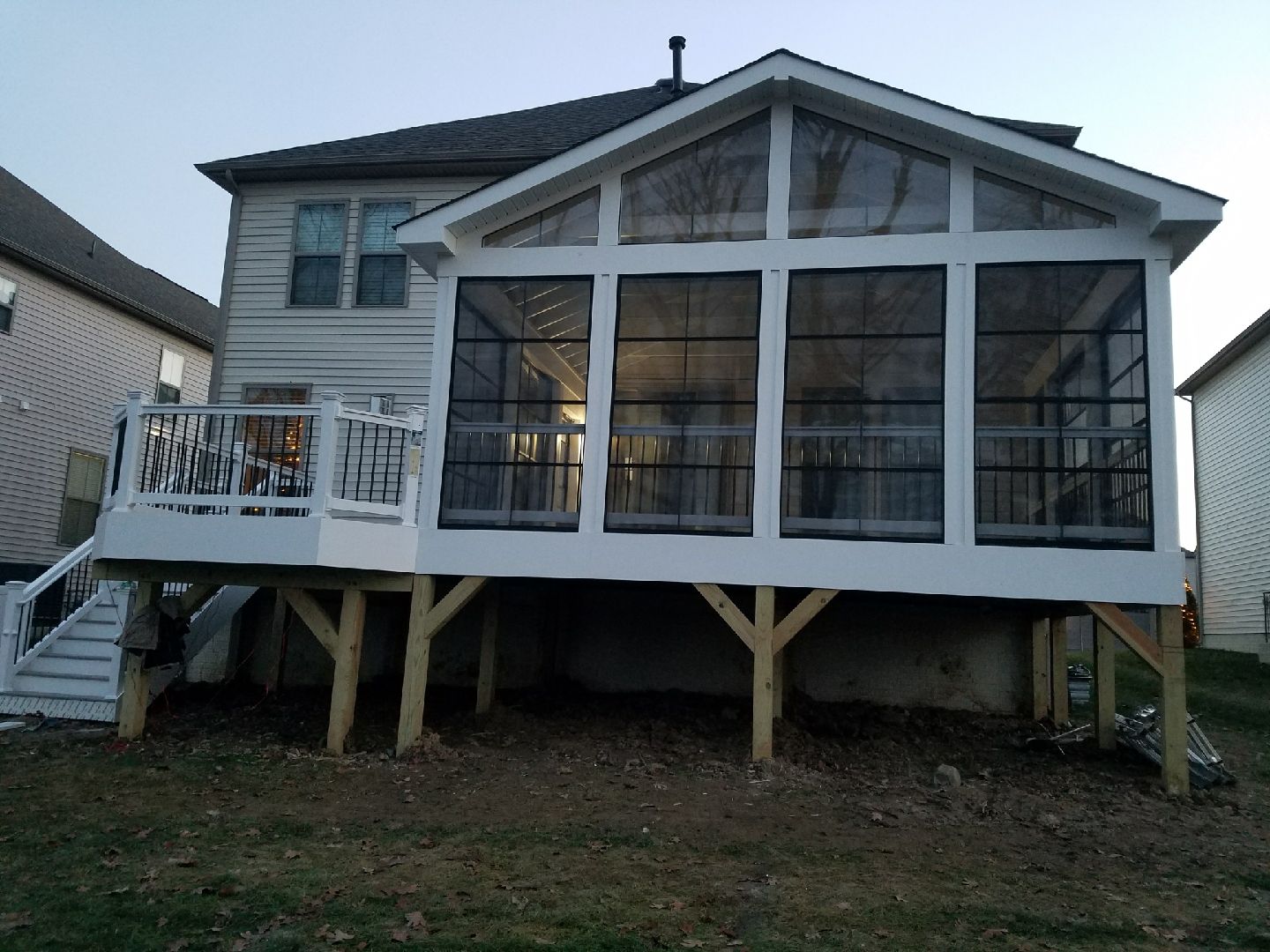 Wooden deck with slatted railing against a brick wall.