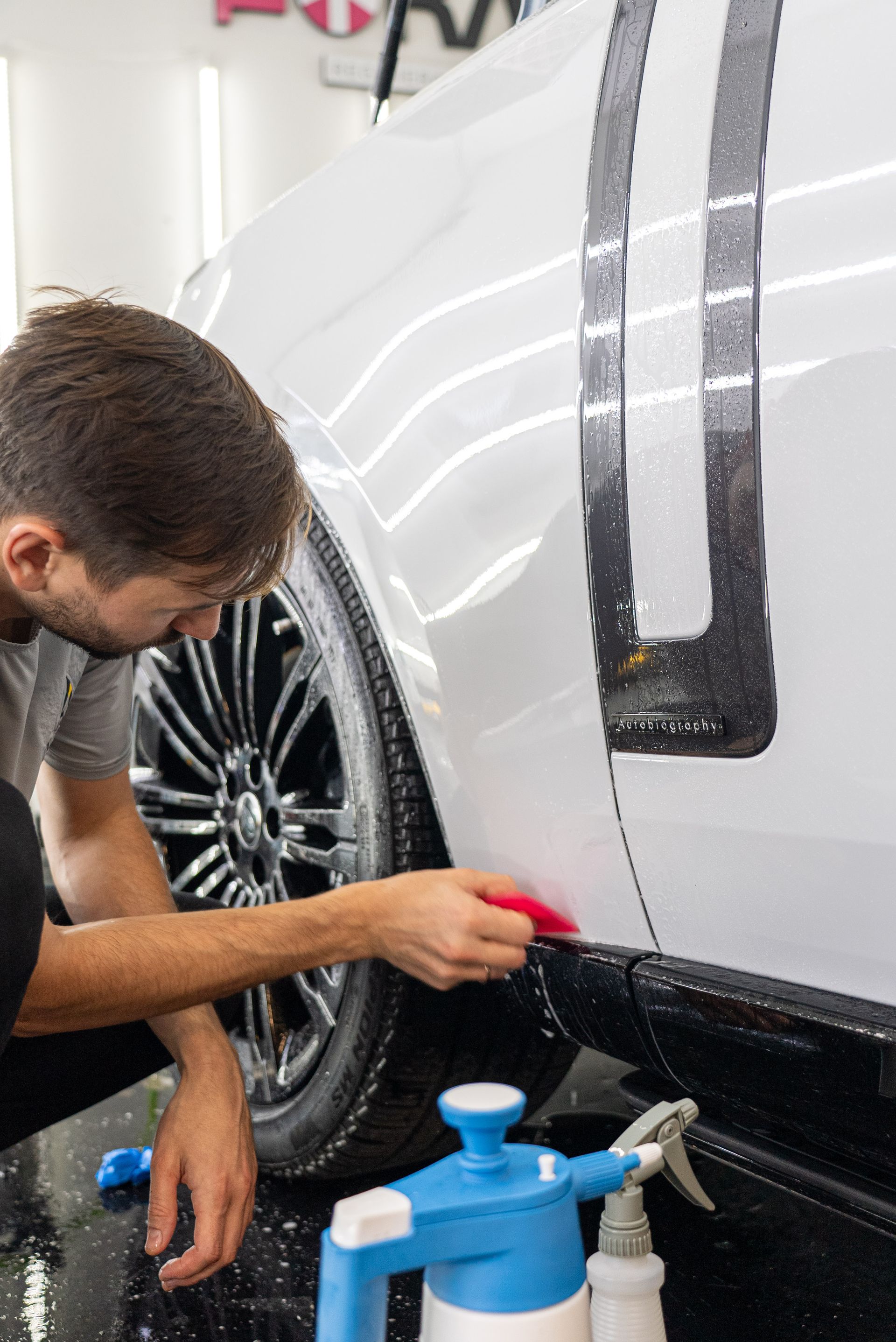 Hand washing a vinyl wrapped car at Lasting Impressions Auto Detailing in Charlotte, NC.