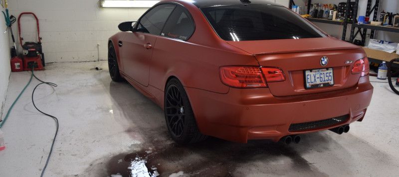 A red bmw is parked in a garage.