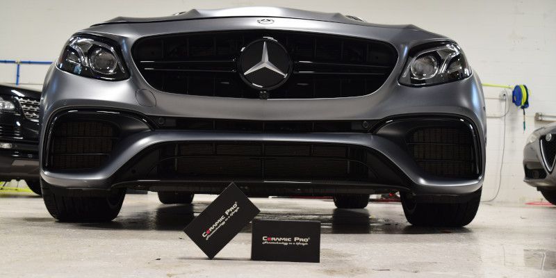 A mercedes is parked in a garage with a box on the ground in front of it