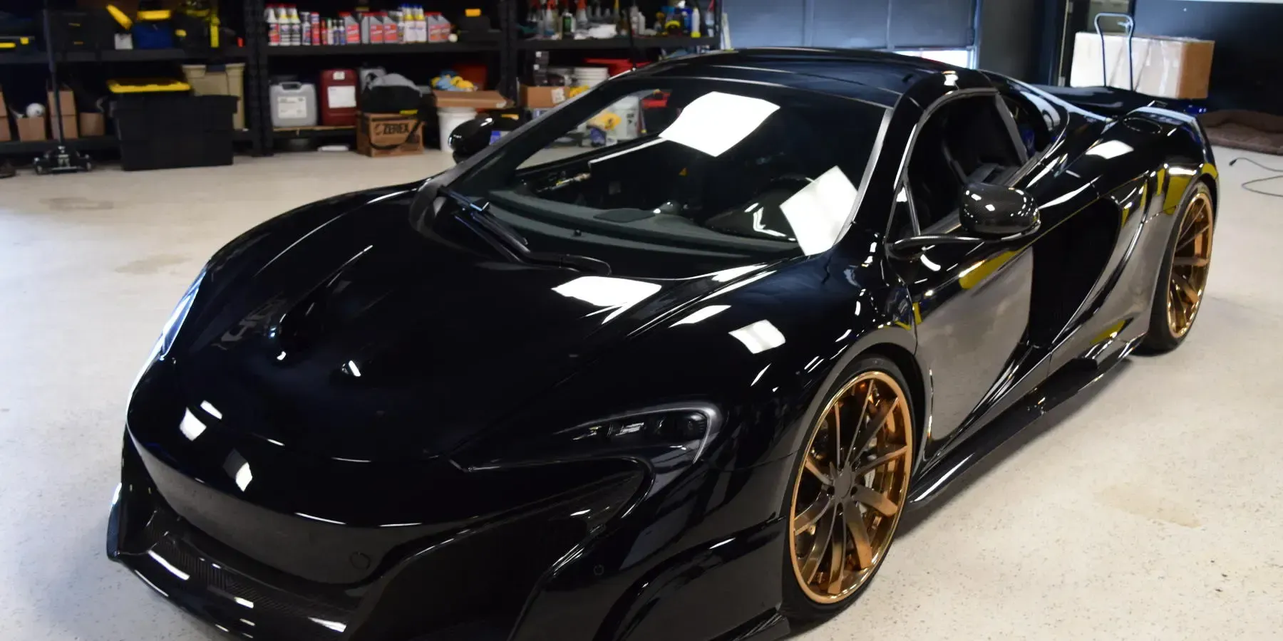 A person wearing black gloves is touching a tire