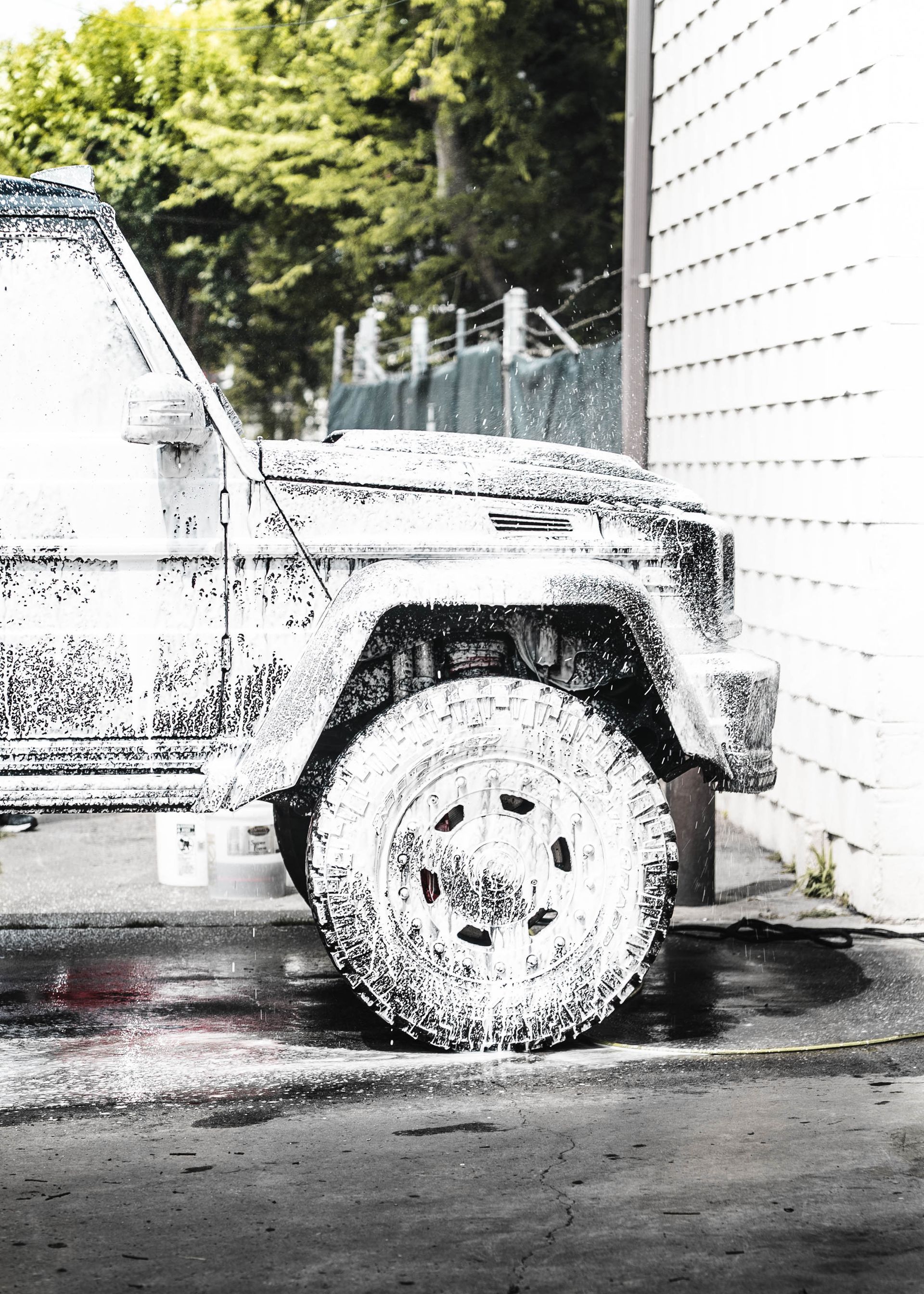 A black and white photo of a jeep covered in foam.