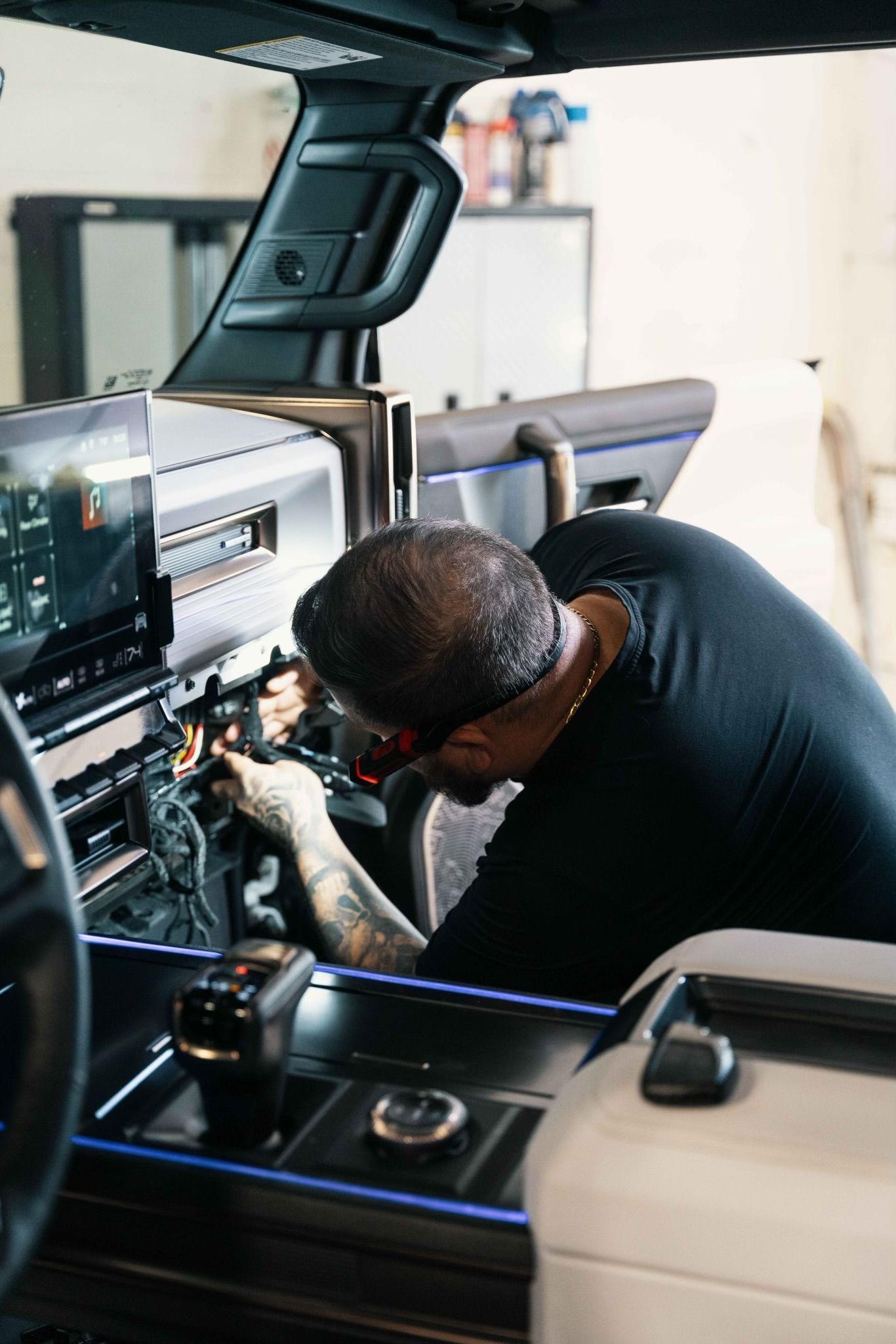 A man is working on the dashboard of a car.
