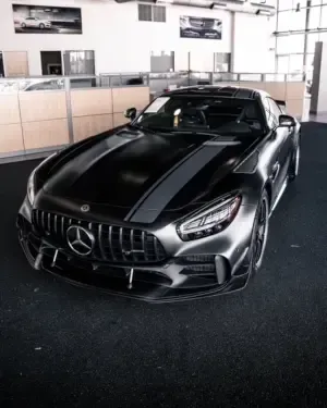 A black mercedes is parked in a showroom
