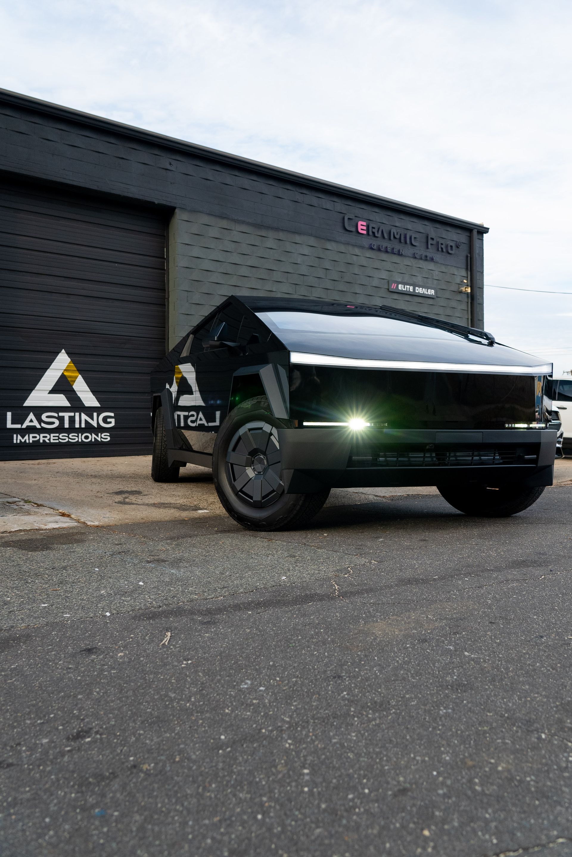 A black truck is parked in front of a building.