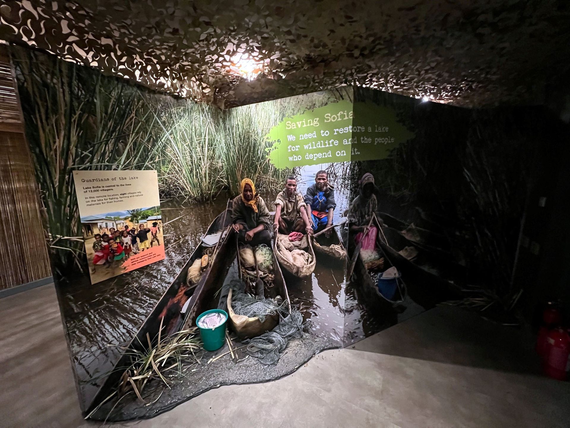 A group of people are sitting in a boat in a room.