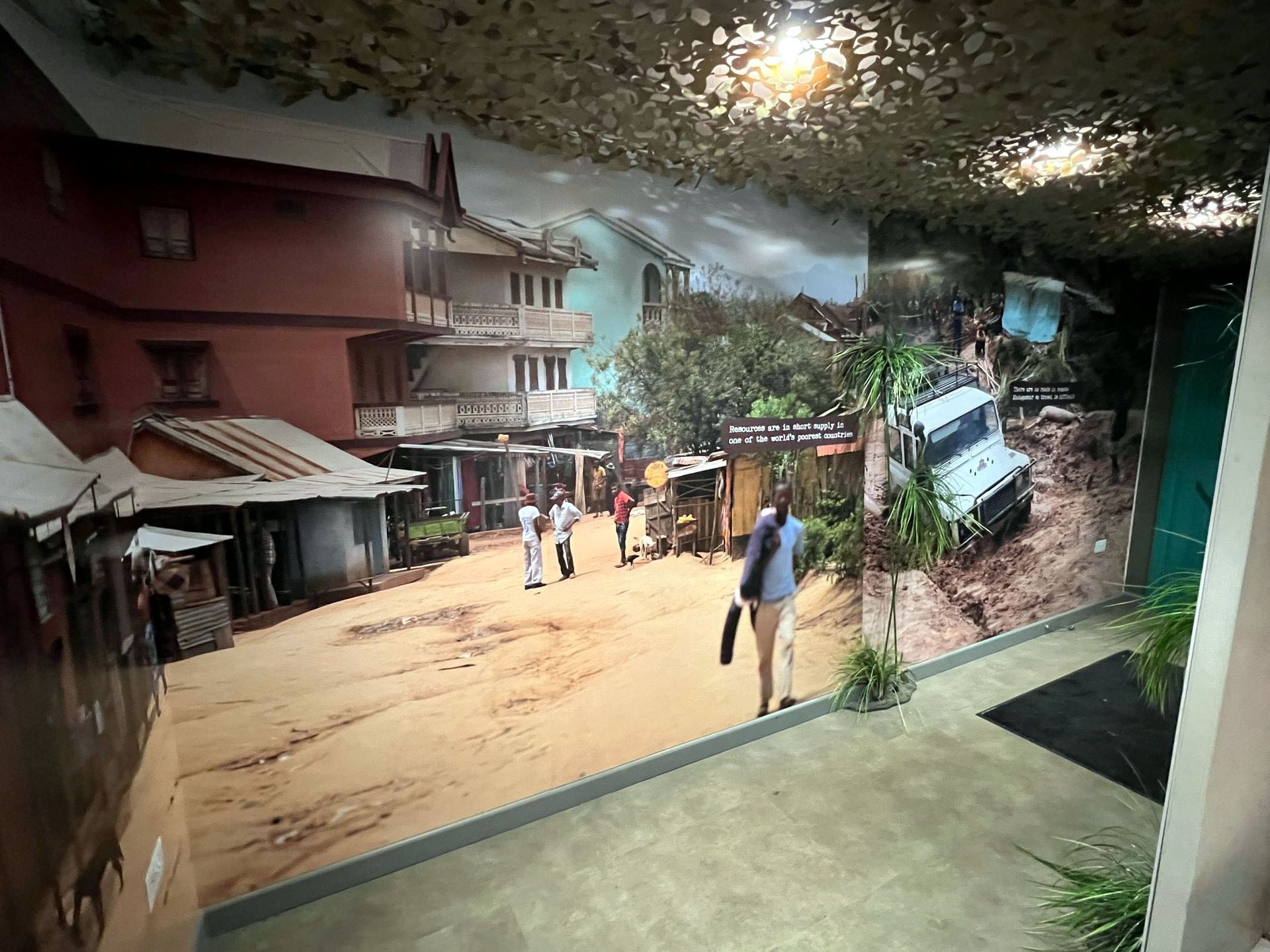 A room with a picture of a village on the wall.