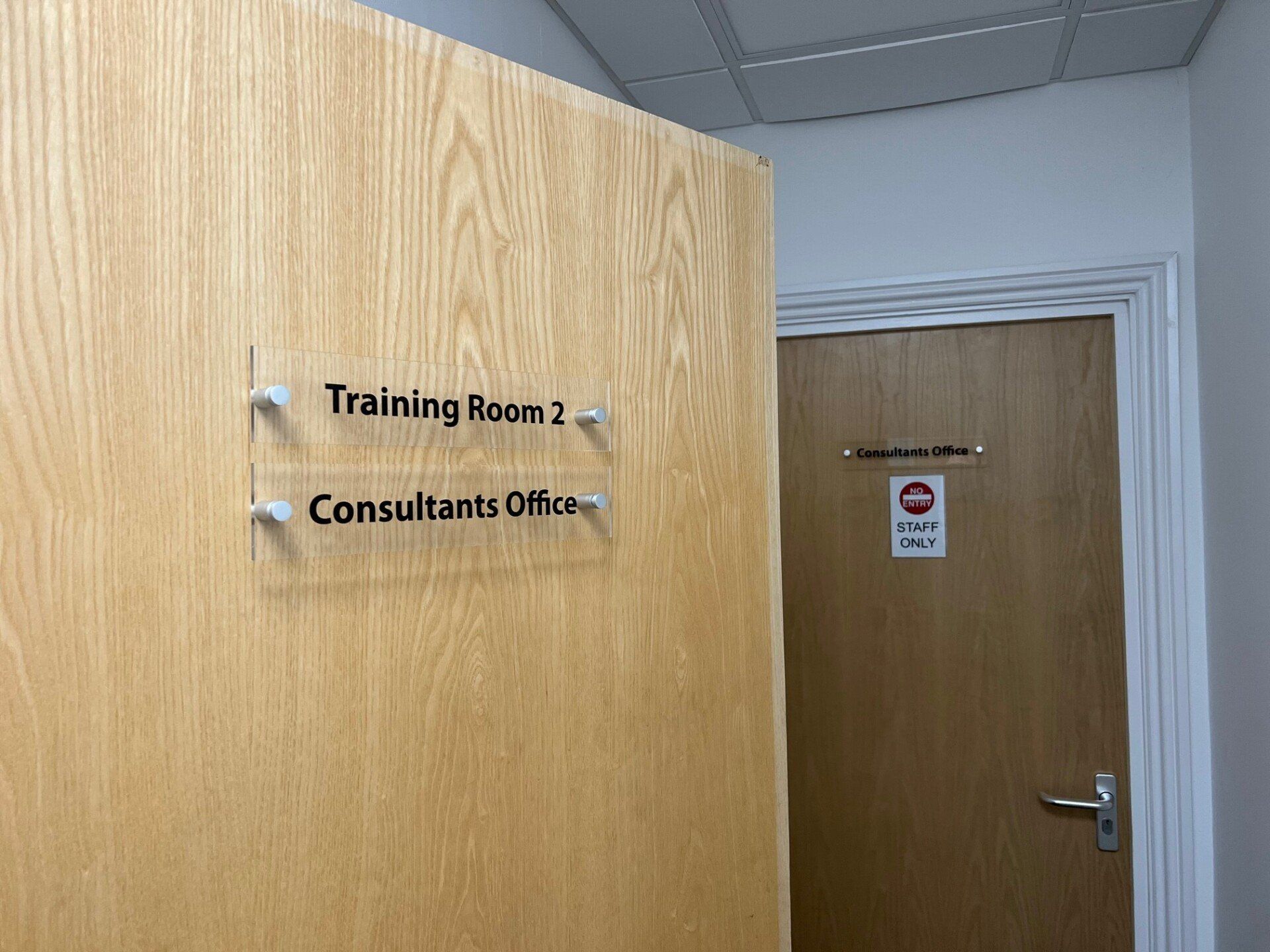 A wooden door with a sign on it that says training room 2 consultants office.