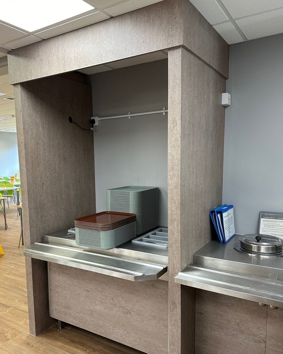 A row of plates are stacked on top of each other in a kitchen.