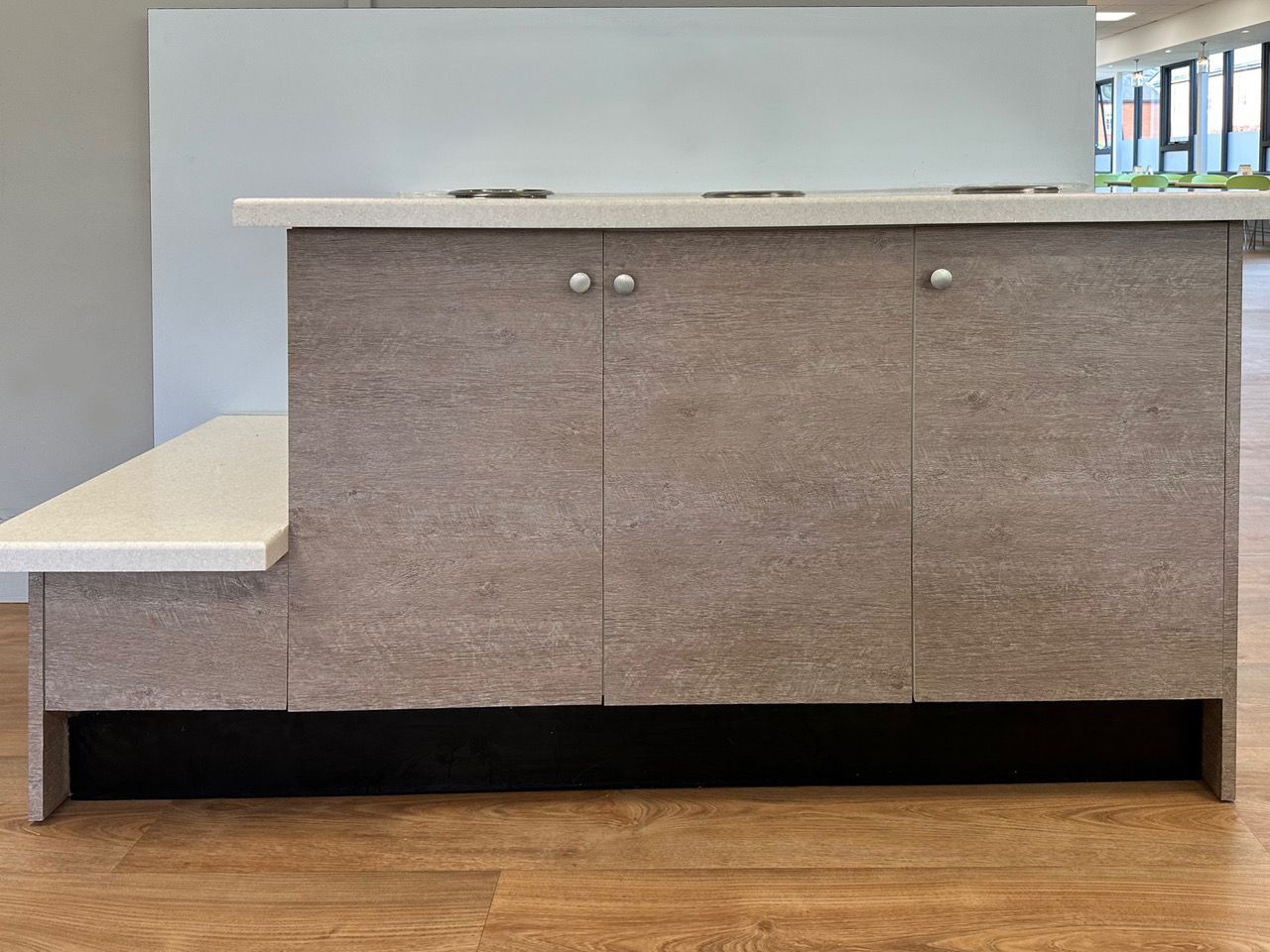A kitchen counter with cabinets and a white counter top.