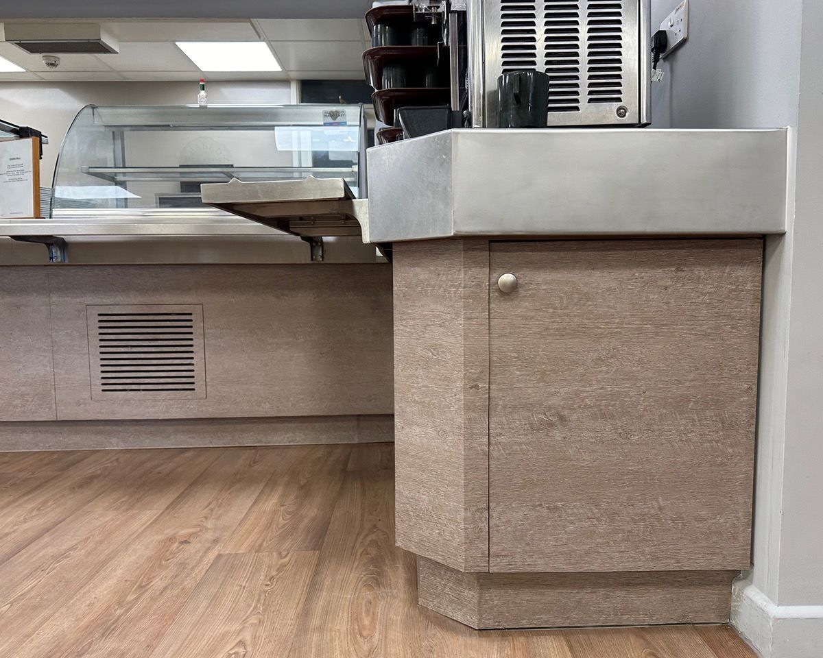 A kitchen with a counter , cabinets , and a refrigerator.